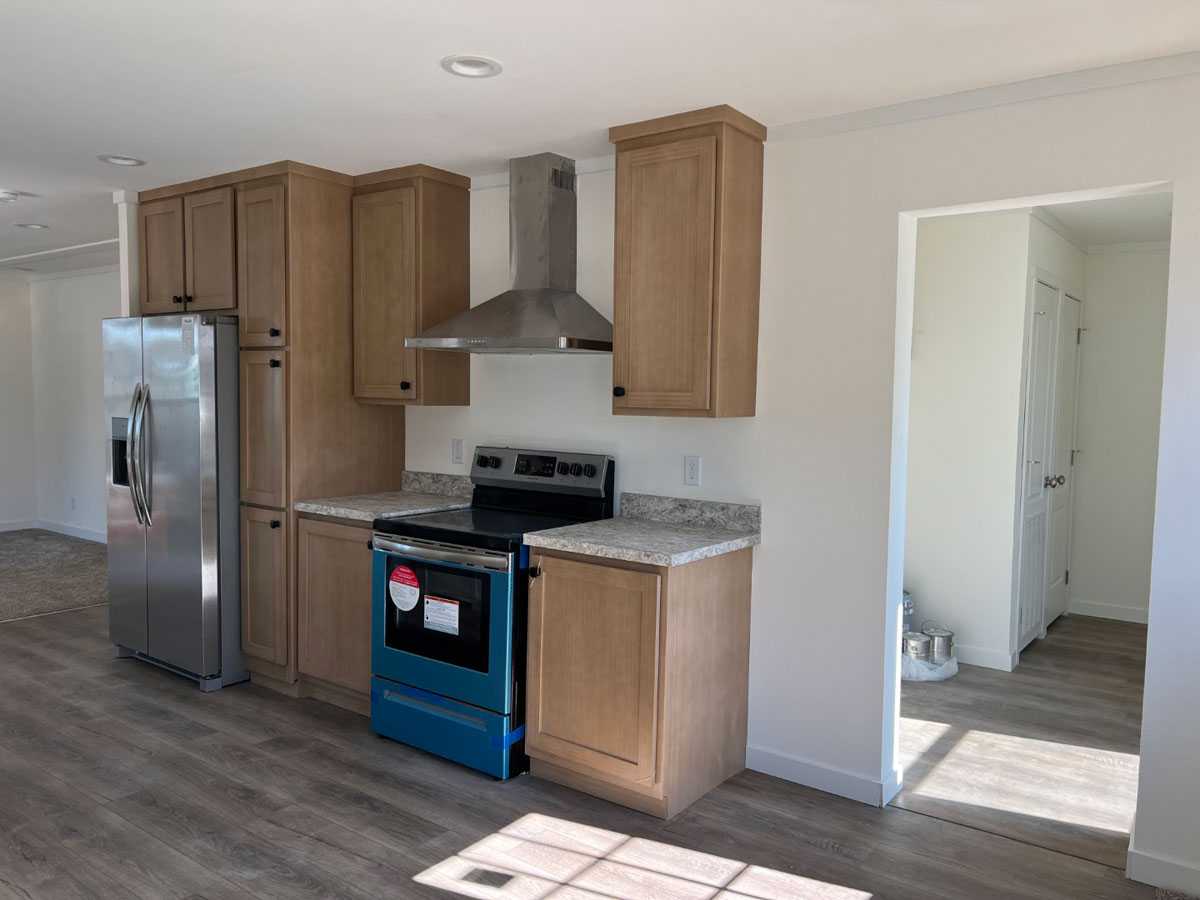 Modern kitchen with stainless steel range hood in the Here Comes the Sun home
