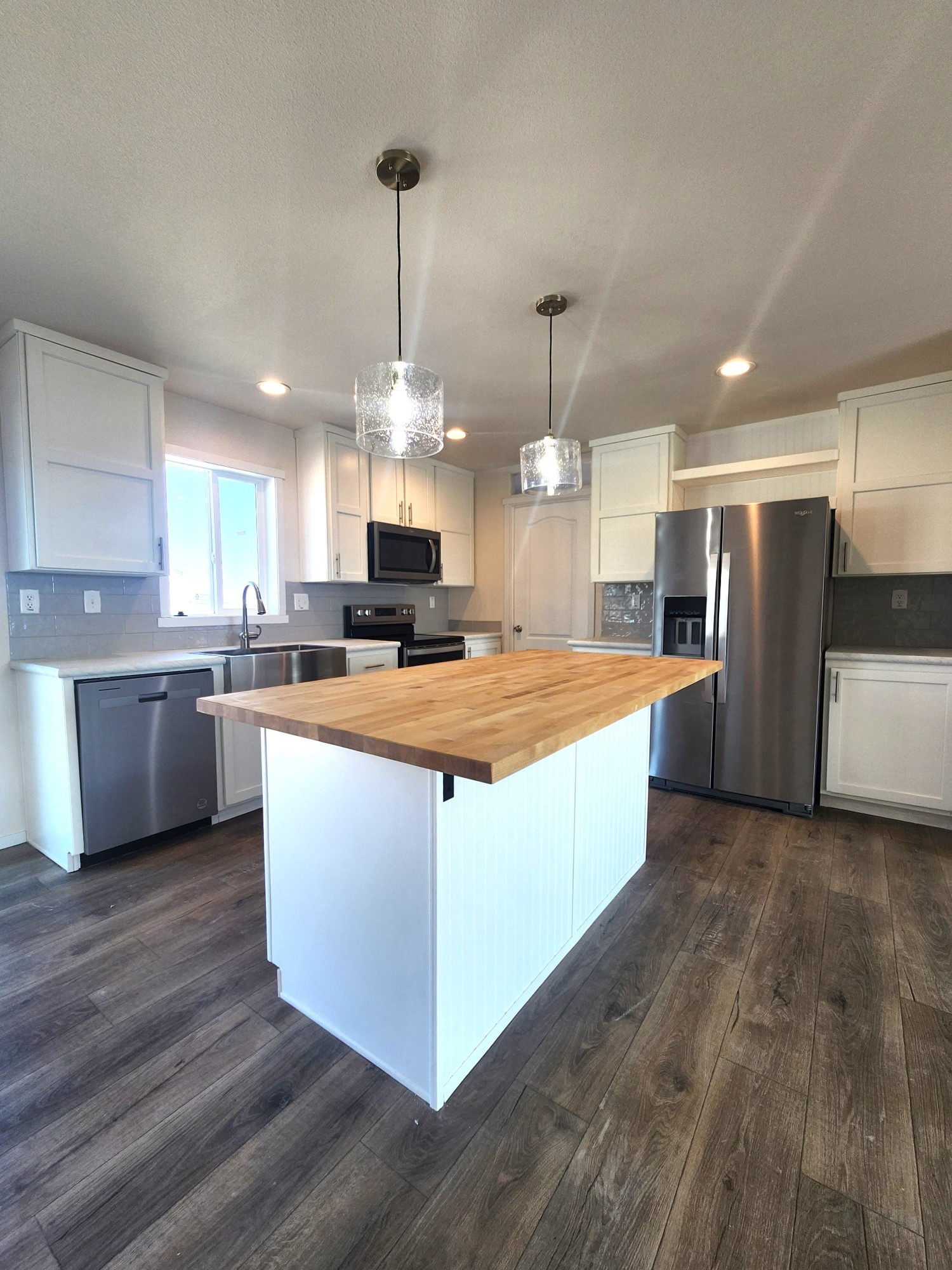 Open concept kitchen with butcher block countertops in Cavco 28683B