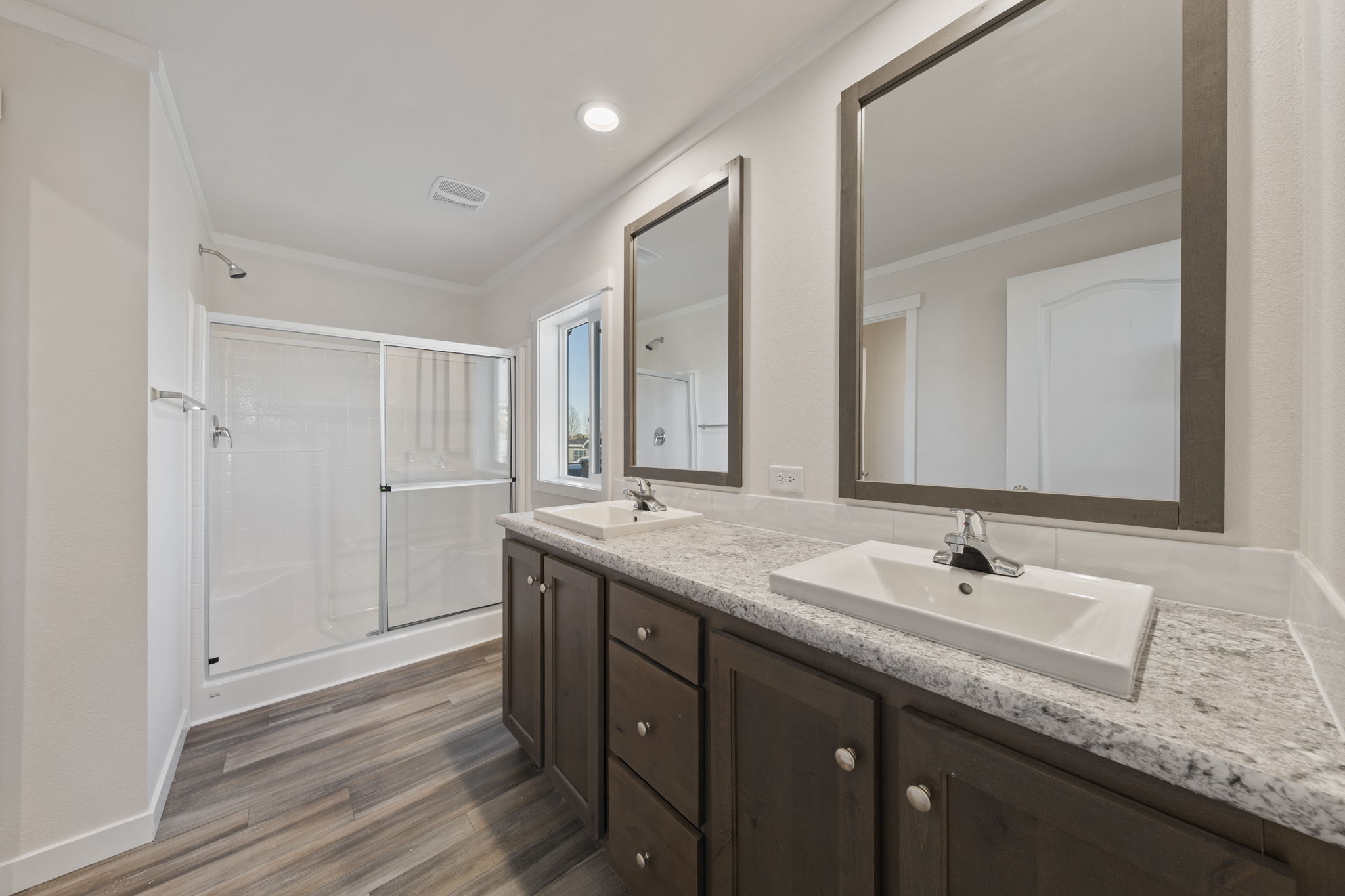 Primary bathroom with double sinks and cabinetry in Cavco Rhythm 28664R home