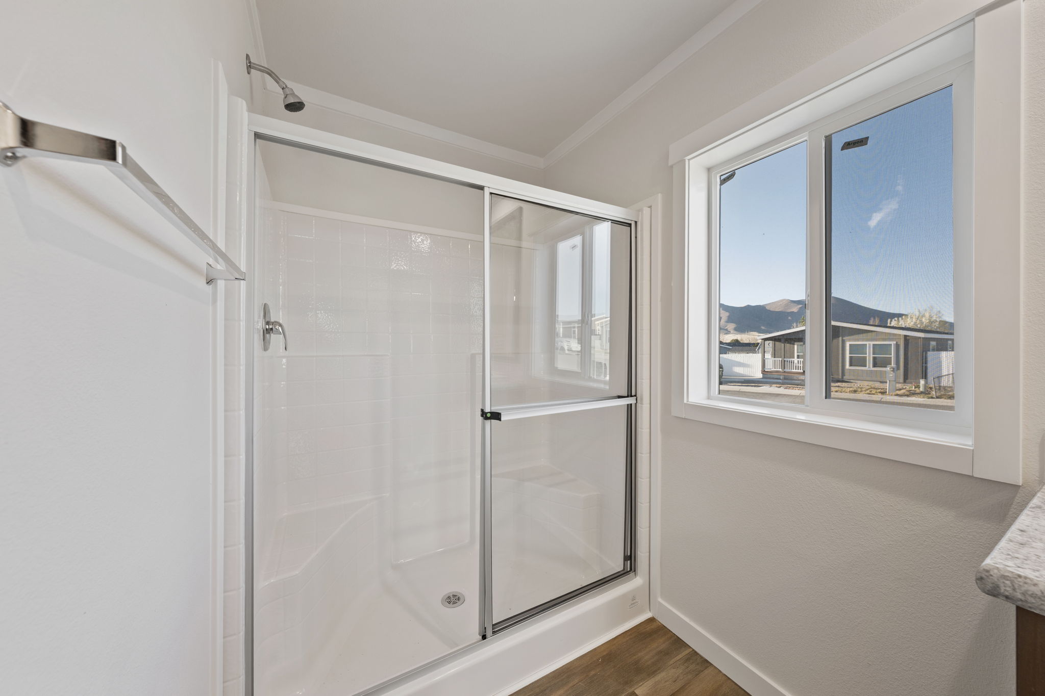 Walk-in shower in primary bathroom of Cavco Rhythm 28664R manufactured home